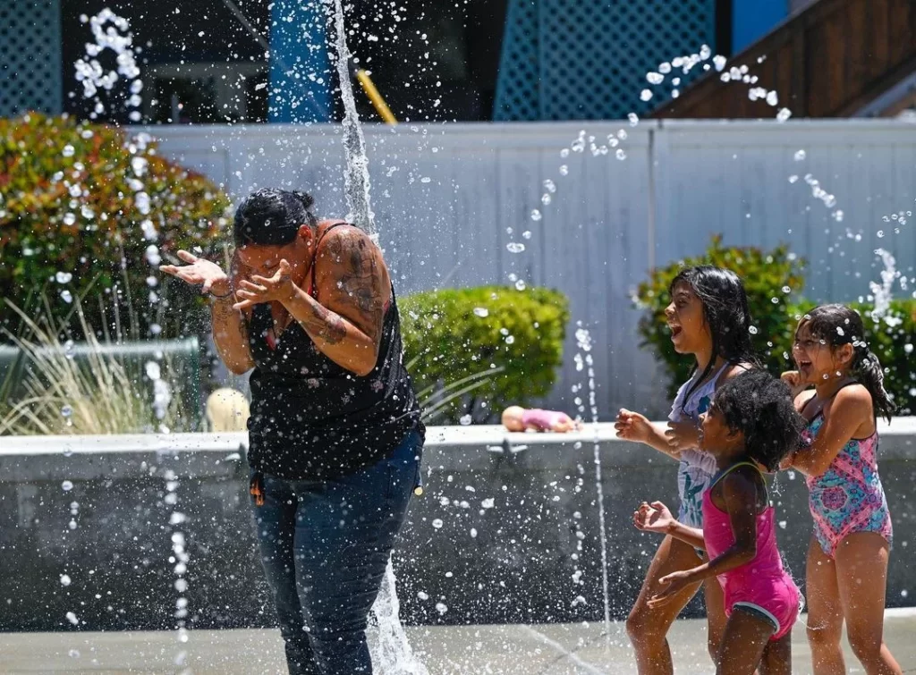 Families joyfully splashing and enjoying the refreshing waters at Adlena Park on a sunny day.