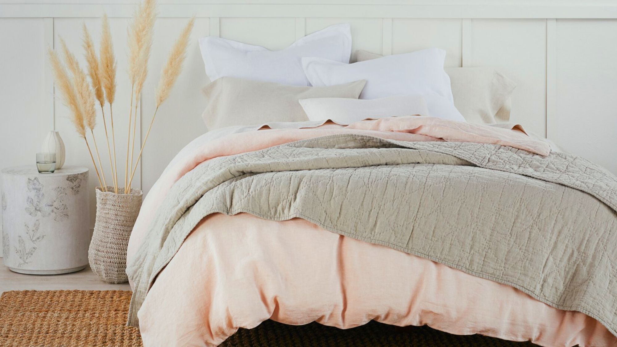 A cozy winter bedding with a pink and gray comforter and pillows, creating a warm and inviting atmosphere
